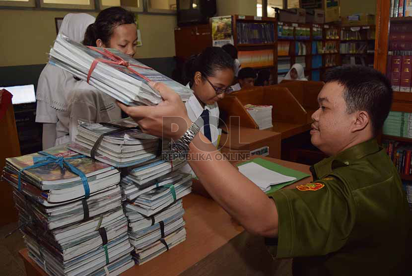 Sejumlah siswa mengembalikan buku-buku kurikulum 2013 kepada pihak sekolah di Sekolah Menegah Pertama Negeri 56, Jakarta Selatan, Senin (15/12). Pihak sekolah akhirnya memberlakukan kurikulum 2013 secara terbatas sesuai himbauan Permendikbud yang mengatur kebijakan penghentian implementasi Kurikulum 2013 dan pengembalian penerapan pendidikan kurikulum 2006 (kurikulum tingkat satuan pendidikan/ KTSP). Republika/Rakhmawaty La'lang